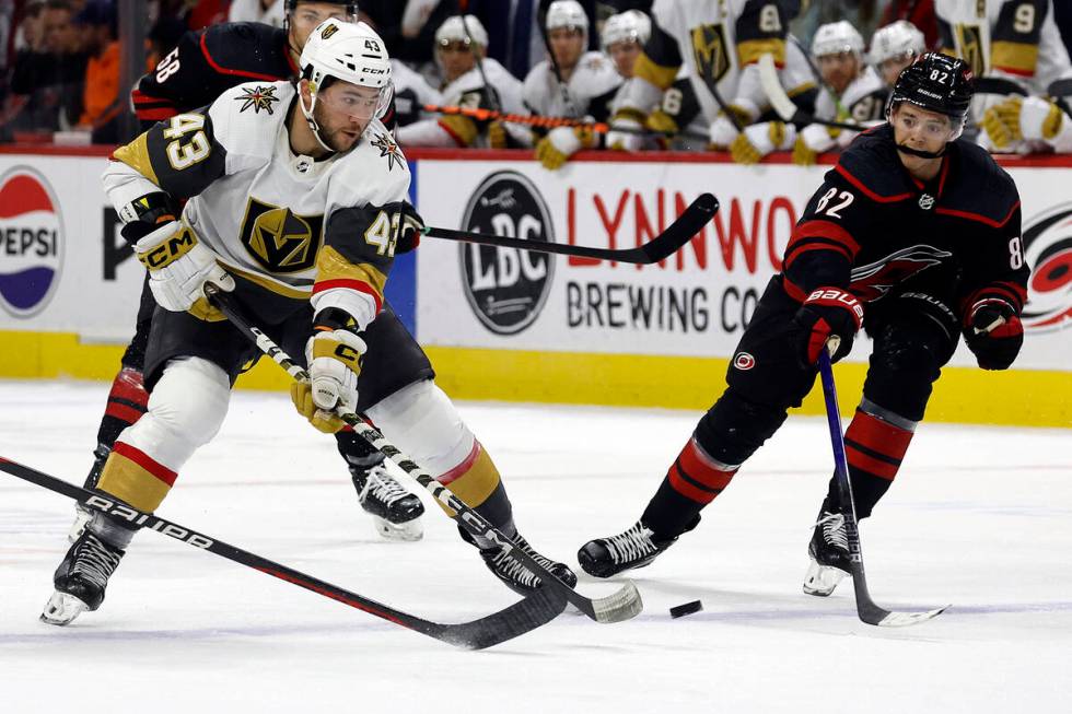 Vegas Golden Knights' Paul Cotter (43) tries to pass the puck around Carolina Hurricanes' Jespe ...