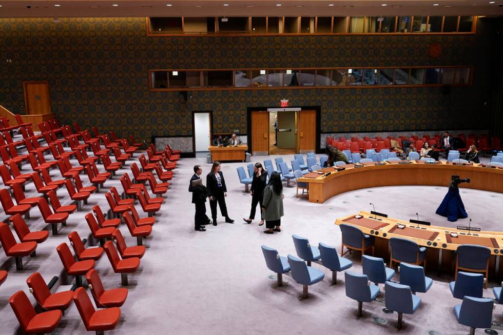 People stand in the mostly empty Security Council chambers at United Nations headquarters, Thur ...