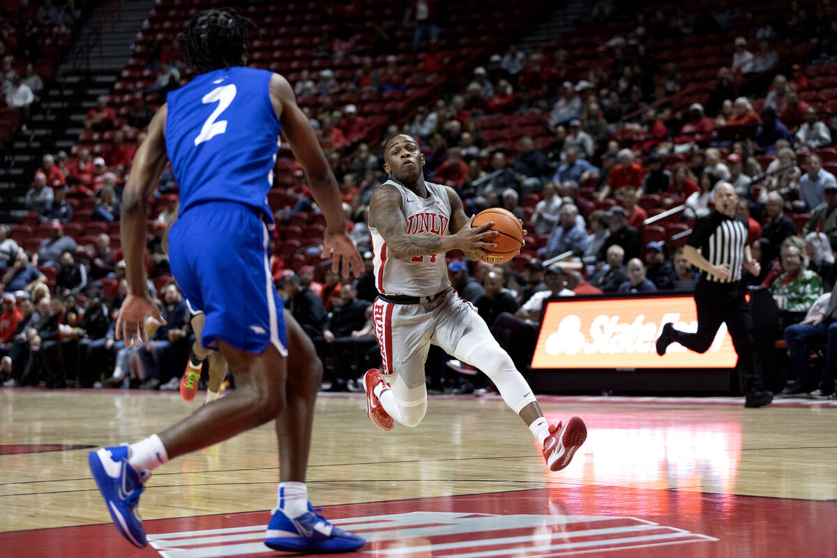 UNLV Rebels guard Jackie Johnson III (24) drives toward the hoop while Hofstra Pride guard Bryc ...