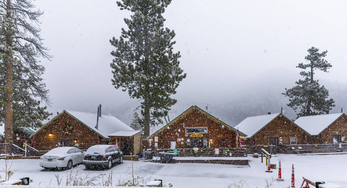 Snow falls heavily about the Mount Charleston Cabins on Friday, Dec. 22, 2023, in Las Vegas. (L ...