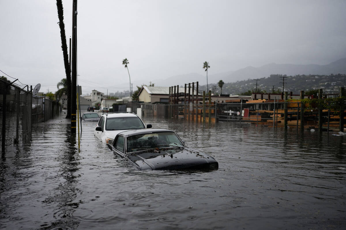Cars are submerged on a flooded street during a rain storm, Thursday, Dec. 21, 2023, in Santa B ...