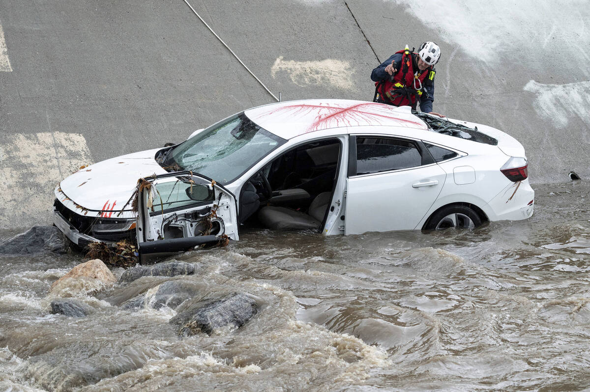 Police, fire, and swift water rescue personal respond to a car in the wash in the 15001 block o ...