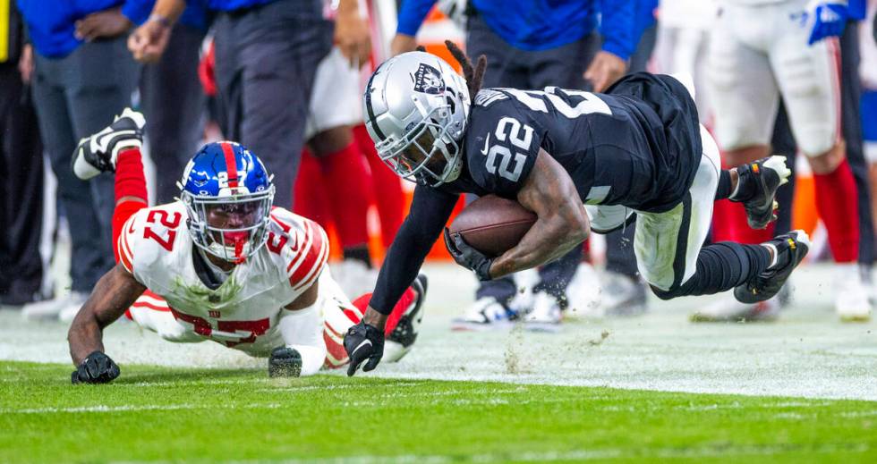 Vegas Raiders running back Ameer Abdullah (22) touches a finger on the turf after a hit from Ne ...