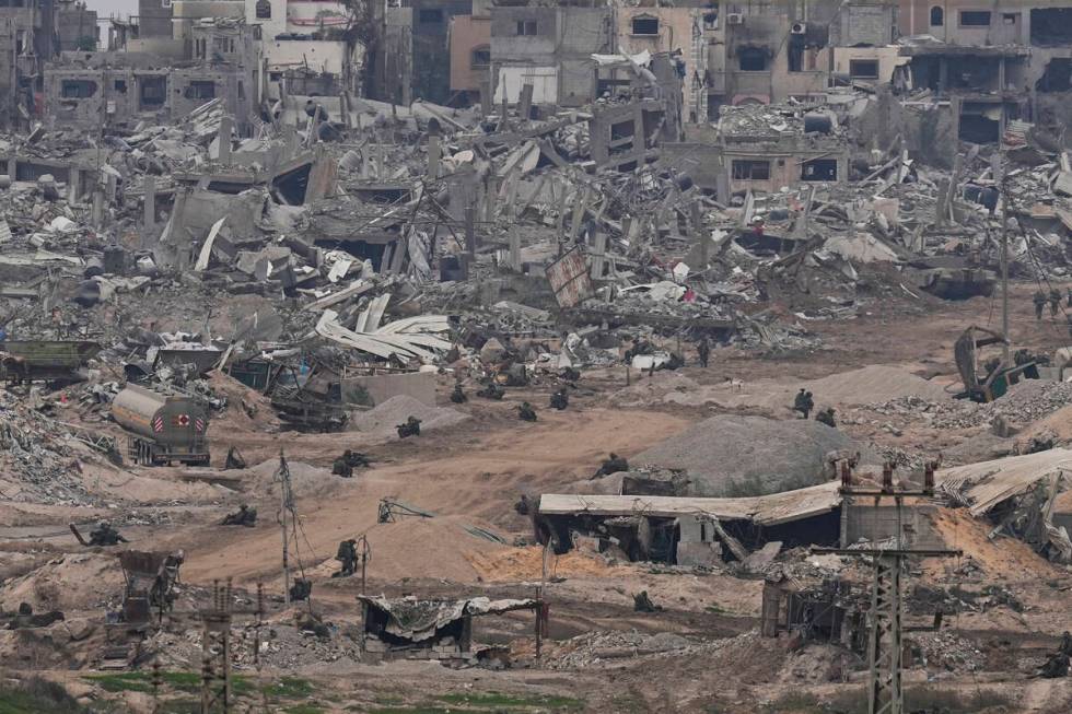 Israeli troops take positions in the Gaza Strip as seen from southern Israel, Thursday, Dec. 21 ...