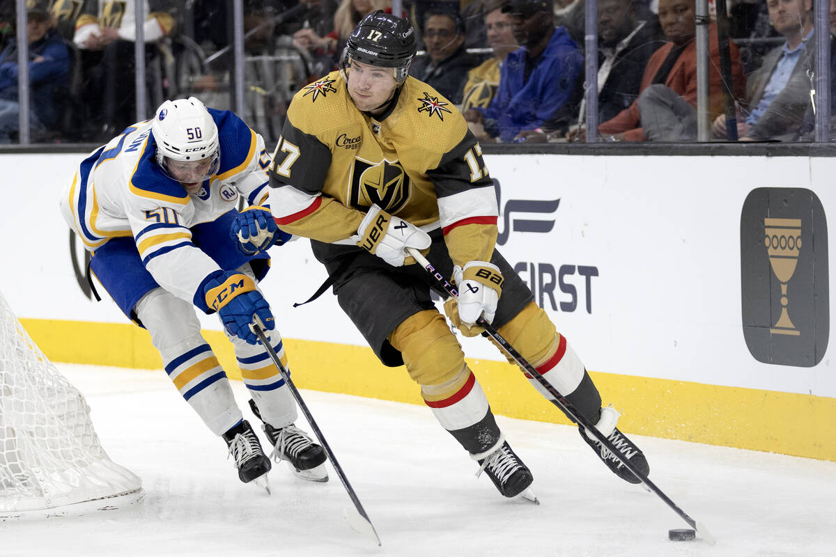 Golden Knights defenseman Ben Hutton (17) skate with the puck against Sabres left wing Eric Rob ...