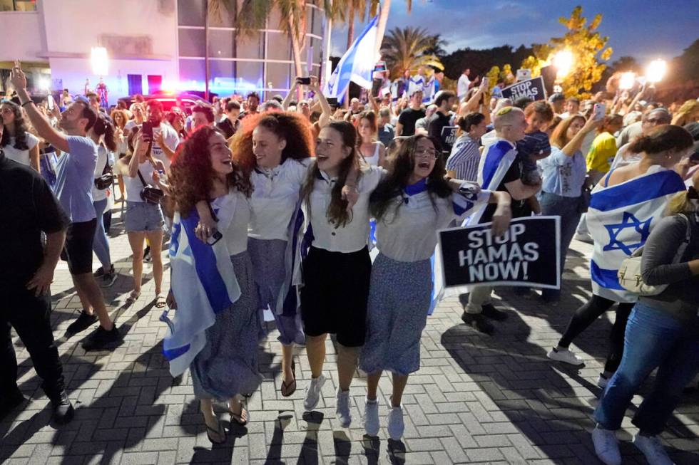 FILE - A group of Israeli girls jump and sing as they attend a rally in support of Israel, at t ...