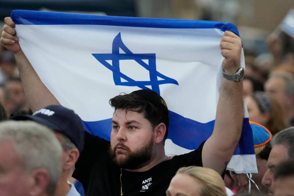 FILE - A man holds up an Israeli flag as he attends a rally in support of Israel, at the Holoca ...