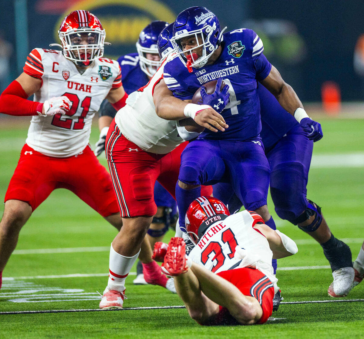 Northwestern Wildcats running back Cam Porter (4) is tackled by Utah Utes safety Nate Ritchie ( ...