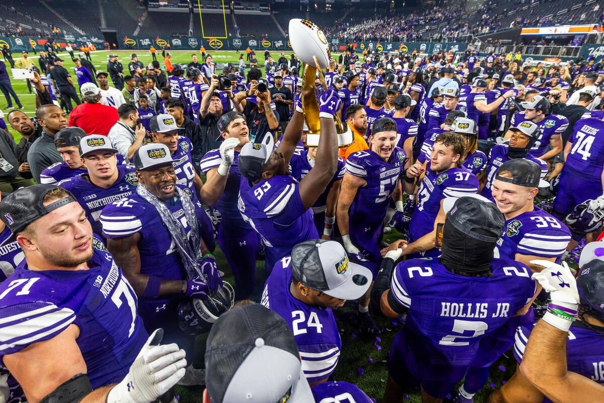 Northwestern Wildcats players celebrate their win with the trophy defeating the Utah Utes 14-7 ...