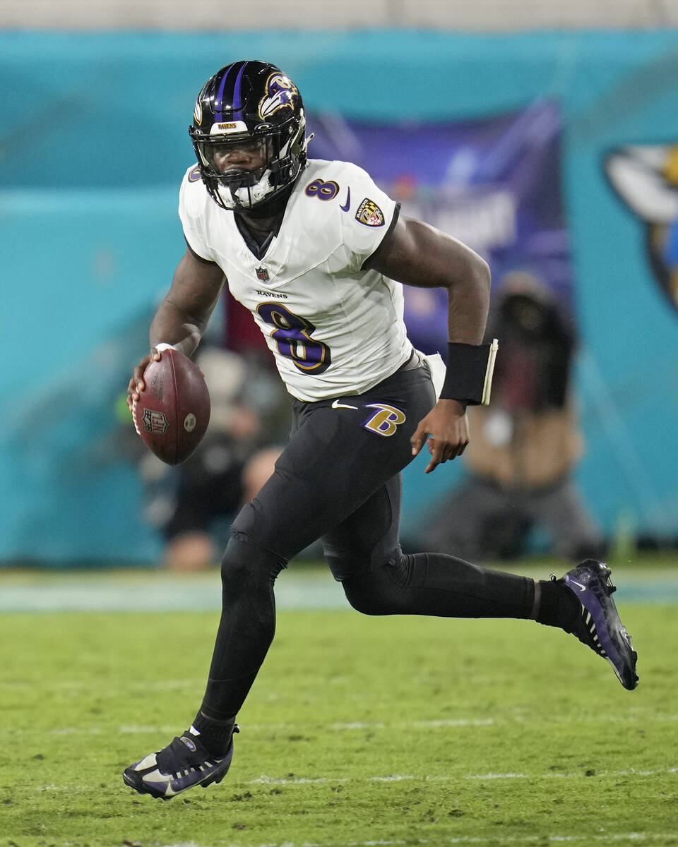 Baltimore Ravens quarterback Lamar Jackson (8) scrambles out of the pocket during the first hal ...