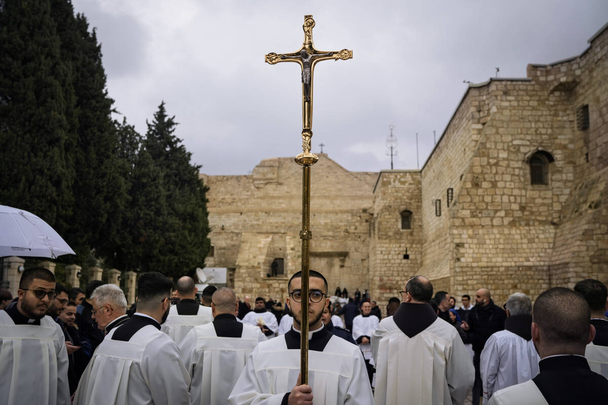 Catholic clergy walk in procession next to the Church of the Nativity, traditionally believed t ...