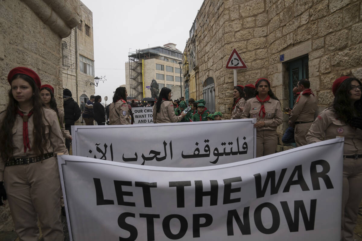 Palestinian scouts hold signs in solidarity with Palestinians in the Gaza Strip calling to end ...