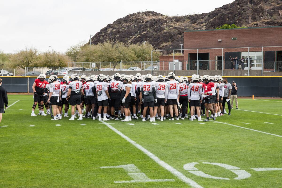 The UNLV football team huddles on the field as the Rebels prepare for Tuesday's Guaranteed Rate ...
