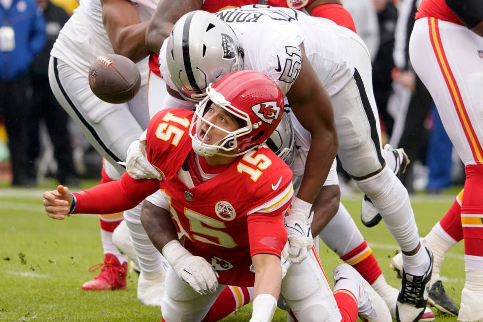 Kansas City Chiefs quarterback Patrick Mahomes (15) fumbles as he is hit by Las Vegas Raiders d ...