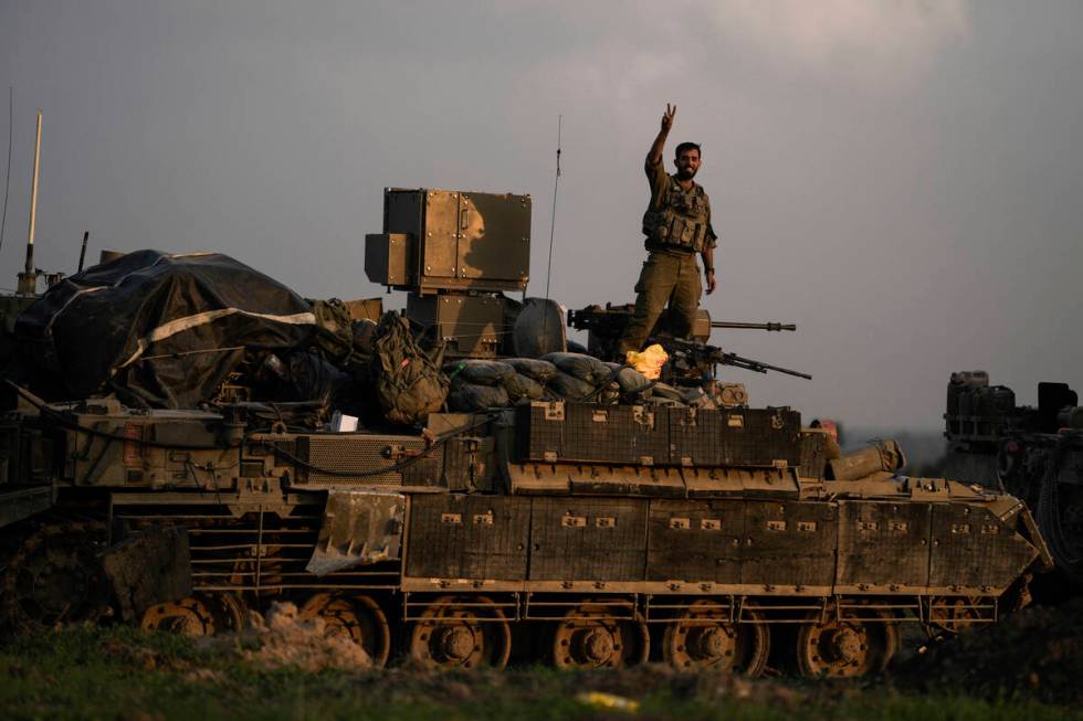 An Israeli soldier flashes a V-sign from an armoured personnel carrier (APC) near the Israeli-G ...