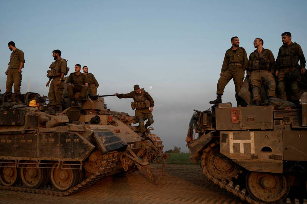 Israeli soldiers stand on top of armoured personnel carriers (APC) near the Israeli-Gaza border ...