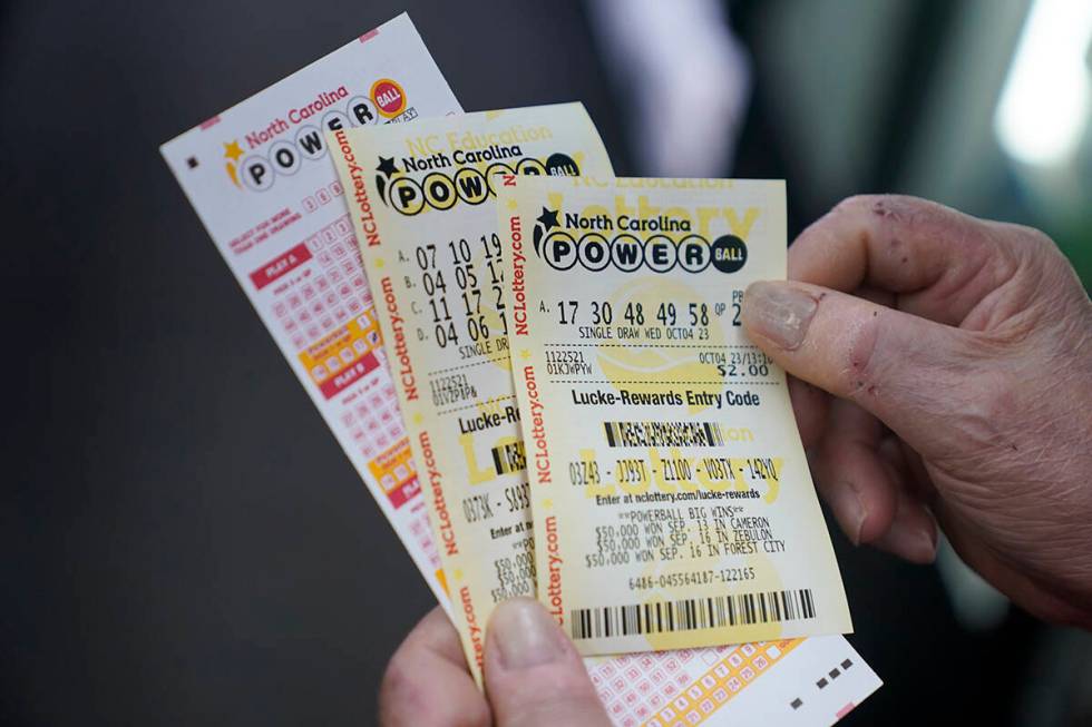Rick Willems shows the Powerball tickets that he purchased at Cigarettes and More on Wednesday, ...