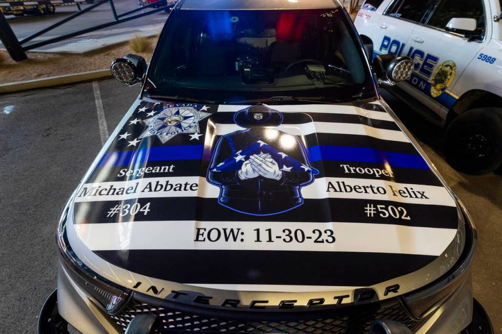 A patrol vehicle has a dedication on its hood during a candlelight vigil for Nevada Highway Pat ...