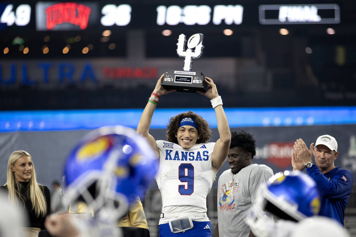 Kansas Jayhawks quarterback Jason Bean (9) holds up his Offensive Player of the Game trophy aft ...