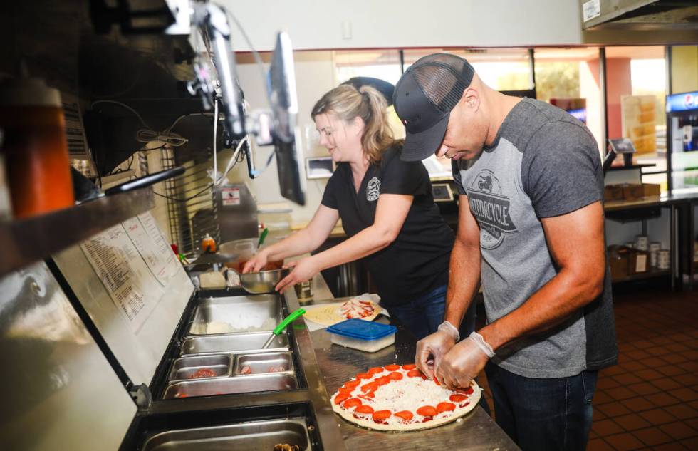 Co-owners and husband and wife duo Gabriel Jordan, right, and Kellie Jordan, left, make a pizza ...