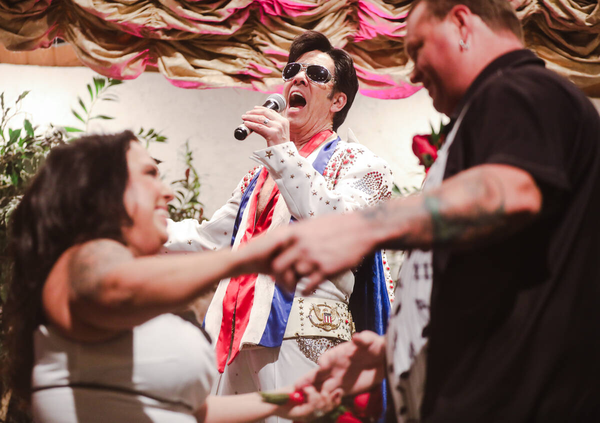 Karie Rockwood dances with Billy Traughber as Elvis impersonator Ron DeCar sings at their weddi ...