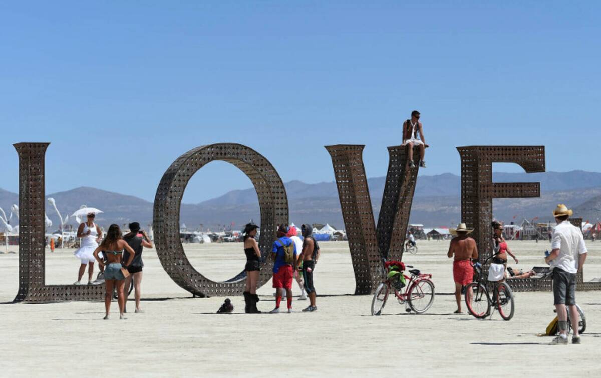 Visitors walk around at the Burning Man festival on the Black Rock Desert of Gerlach, Nev., on ...