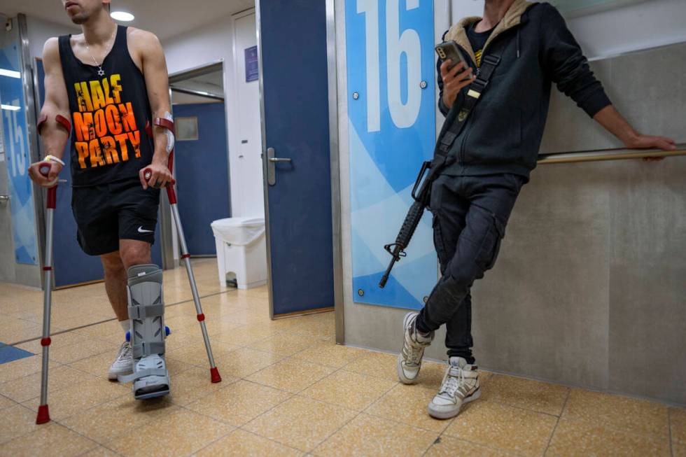 An Israeli soldier wounded in the war with Hamas walks with crutches in the rehabilitation divi ...