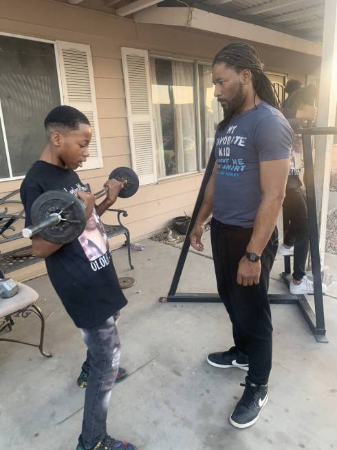 Keon Young, 13, lifting weights with his uncle Robert Cook. (Courtesy of Robert Cook)