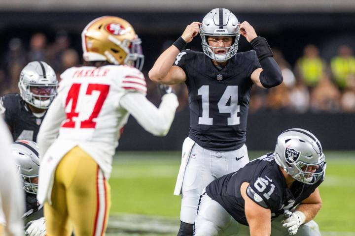 Raiders quarterback Chase Garbers (14) signals a play to teammates during the second half of a ...