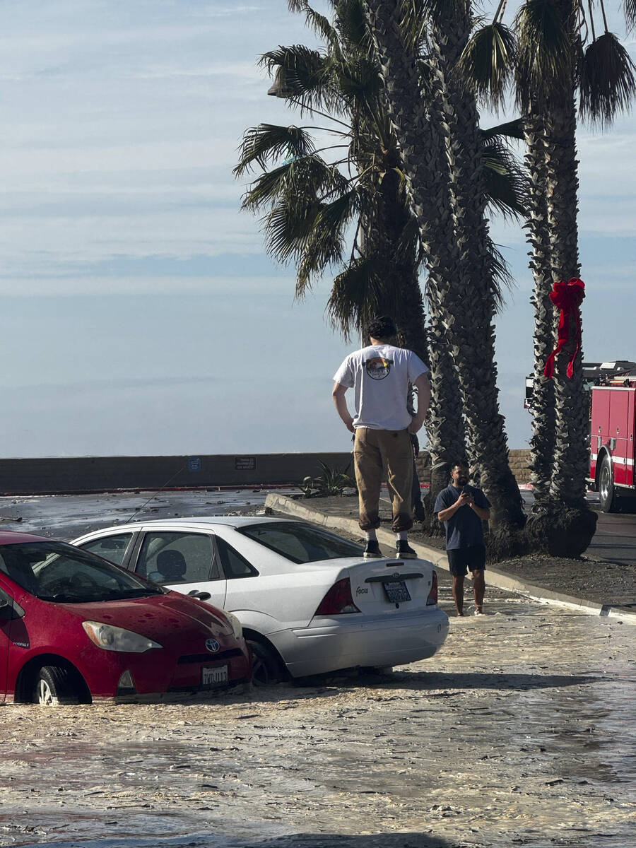 This photo provided by Duke's Beach Grill, water from high waves food the streets of Ventura, C ...