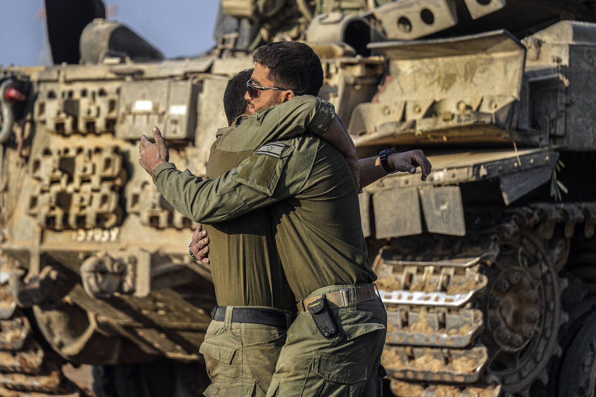 Israeli soldiers embrace after arriving from combat in the Gaza Strip at an army staging area i ...