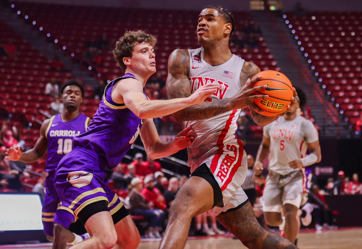 UNLV Rebels guard Luis Rodriguez (15) drives to the basket past Carroll College Fighting Saints ...