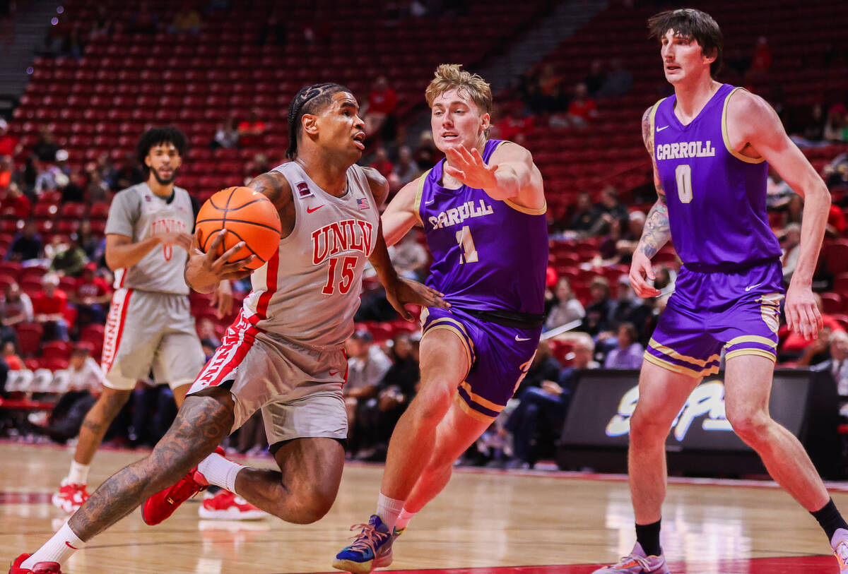 UNLV Rebels guard Luis Rodriguez (15) drives to the basket past Carroll College Fighting Saints ...