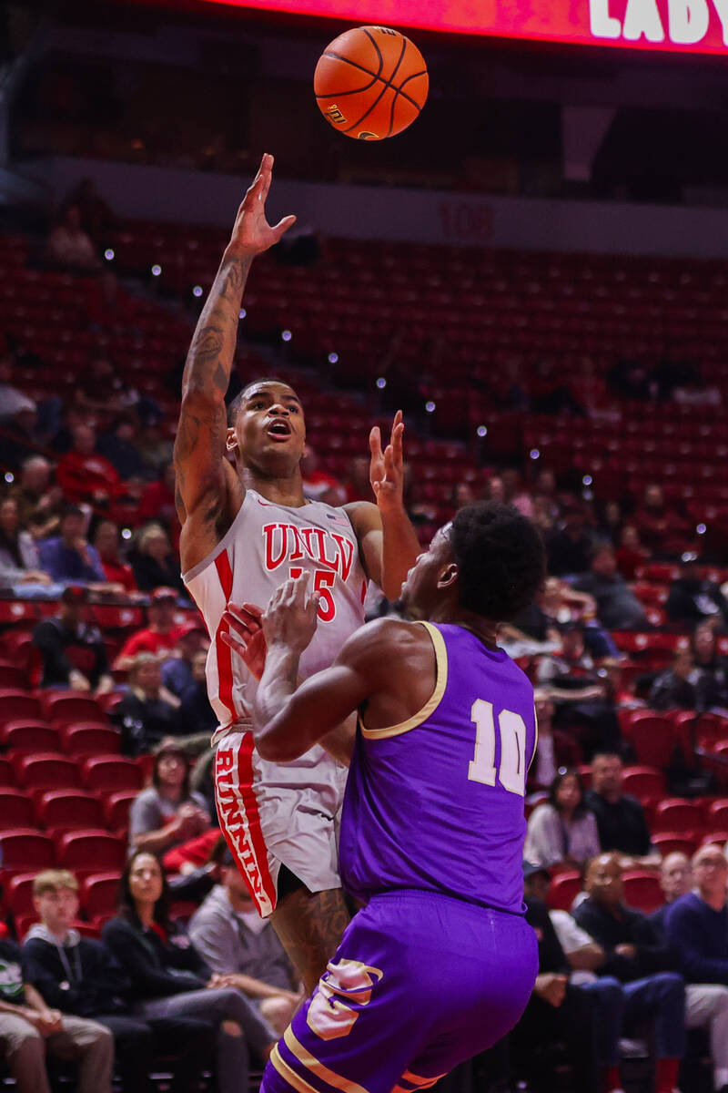 UNLV Rebels guard Luis Rodriguez (15) shoots a layup around Carroll College Fighting Saints gua ...