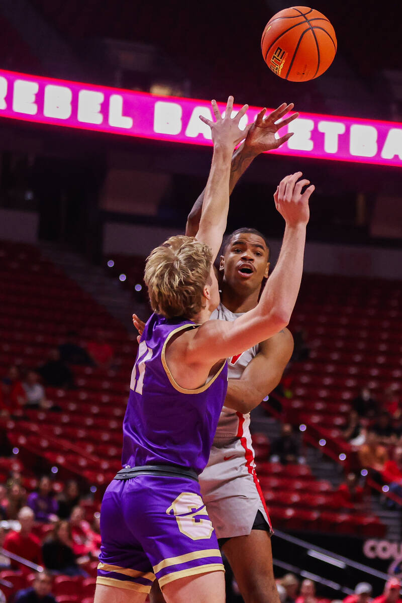 Carroll College Fighting Saints guard Andrew Cook (11) attempts to block UNLV Rebels guard Luis ...