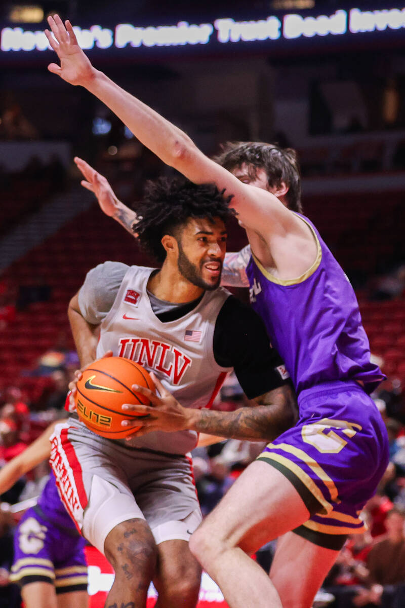 UNLV Rebels forward Isaiah Cottrell (0) moves the ball around Carroll College Fighting Saints c ...