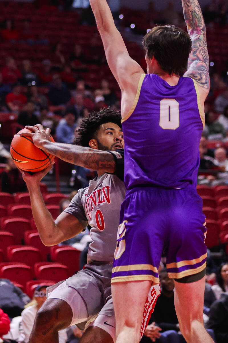 UNLV Rebels forward Isaiah Cottrell (0) looks to pass the ball around Carroll College Fighting ...
