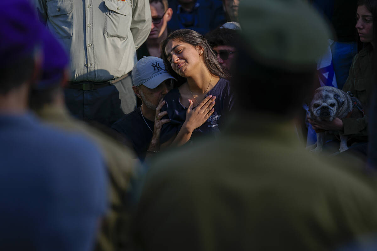 Mourners gather in grief around the grave of Israeli soldier Captain Harel Ittah during his fun ...