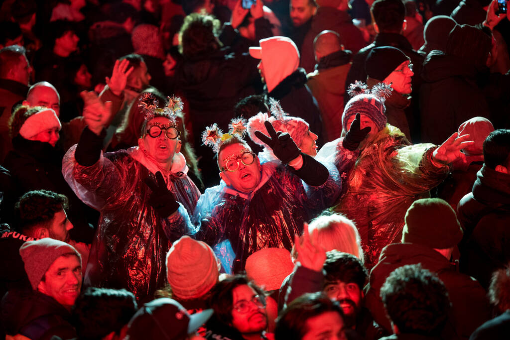 People celebrate the new year during the New Year's Eve at the Brandenburg Gate party, Sunday, ...