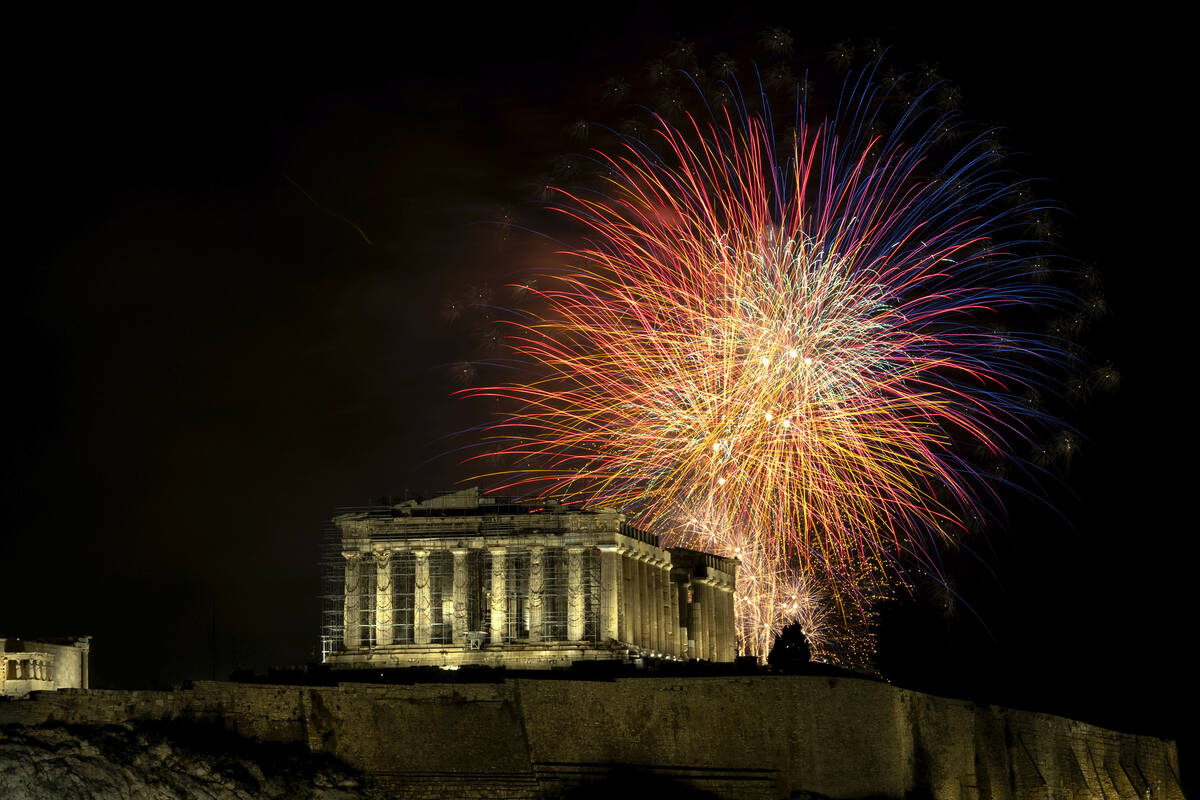 Fireworks explode over the ancient Parthenon temple at the Acropolis hill during New Year's cel ...
