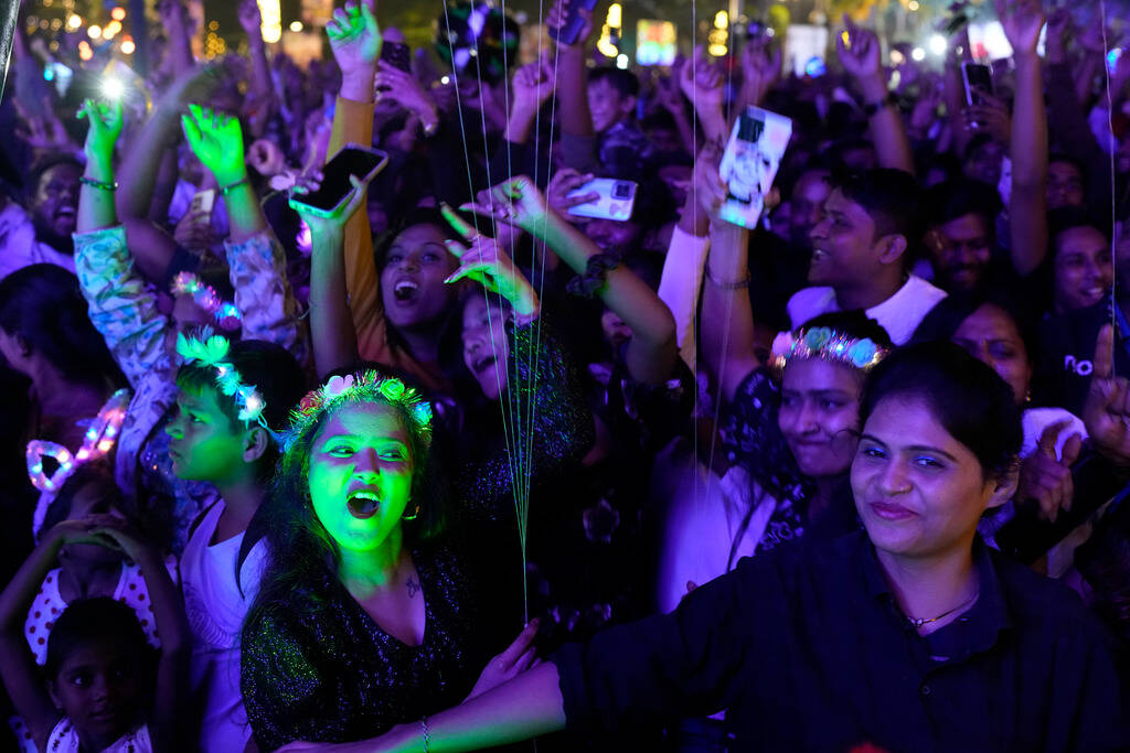 People celebrate New Year's at a promenade in Mumbai, India, Monday, Jan. 1, 2024. (AP Photo/Ra ...