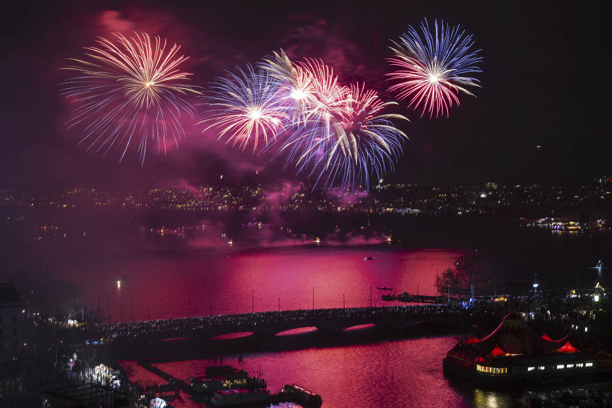 Fireworks illuminate the sky above Lake Zurich, Switzerland, during the New Year's Eve festivit ...