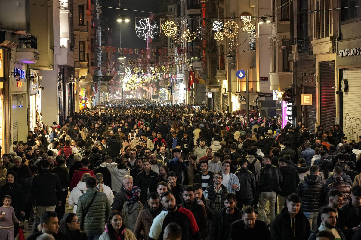 People walk as they celebrate New Year's Eve in popular Istiklal Street near the city's main Ta ...