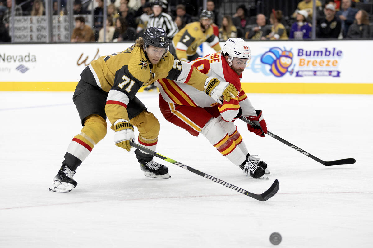 Golden Knights center William Karlsson (71) and Flames center Dillon Dube (29) race for the puc ...
