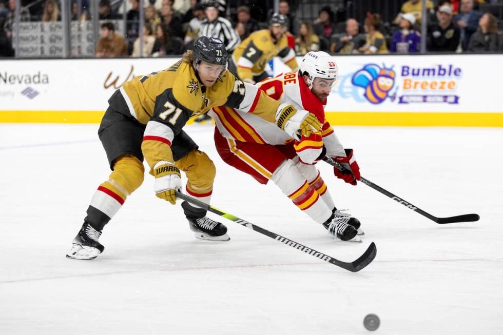 Golden Knights center William Karlsson (71) and Flames center Dillon Dube (29) race for the puc ...