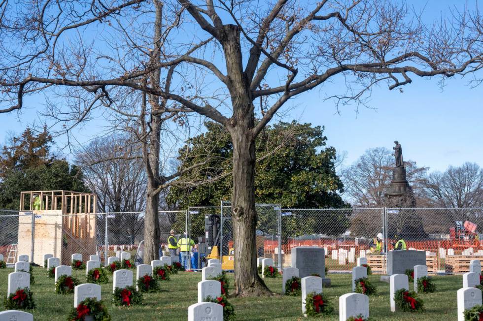 Worker build a crate to hold the statue, left, as they prepare to remove a Confederate Memorial ...