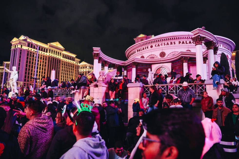 Crowds of people line the Strip in front of Caesars Palace for New Year celebrations on Sunday, ...