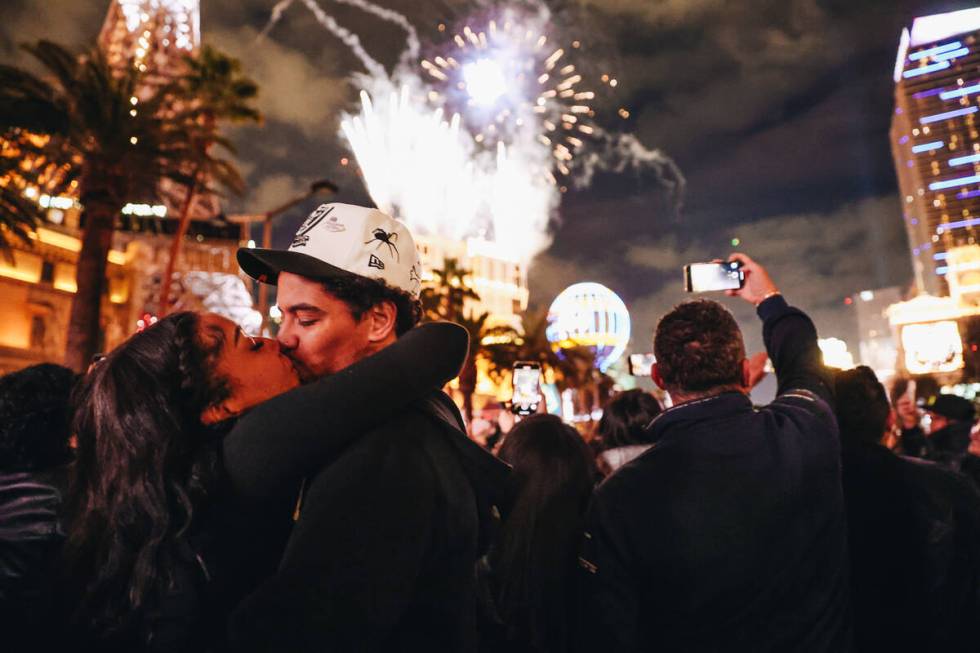 Reonna Holmes, left, kisses her boyfriend, Eric Lovato at midnight as New Year’s firewor ...