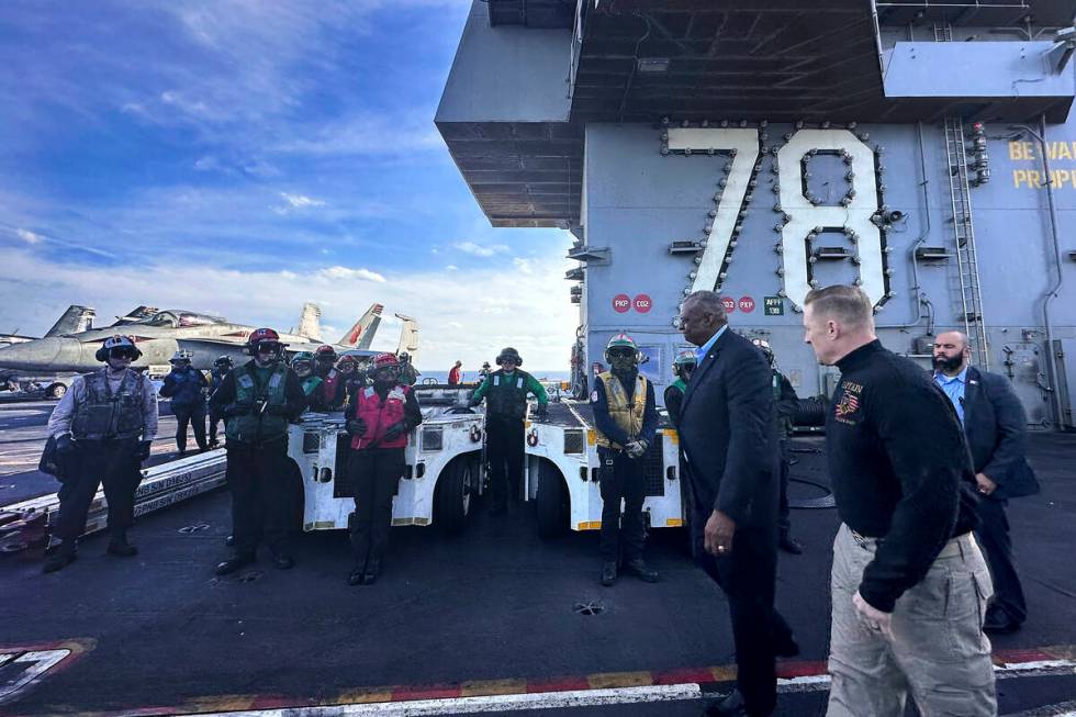 Defense Secretary Lloyd Austin, front left, walks next to the commanding officer of the USS Ger ...