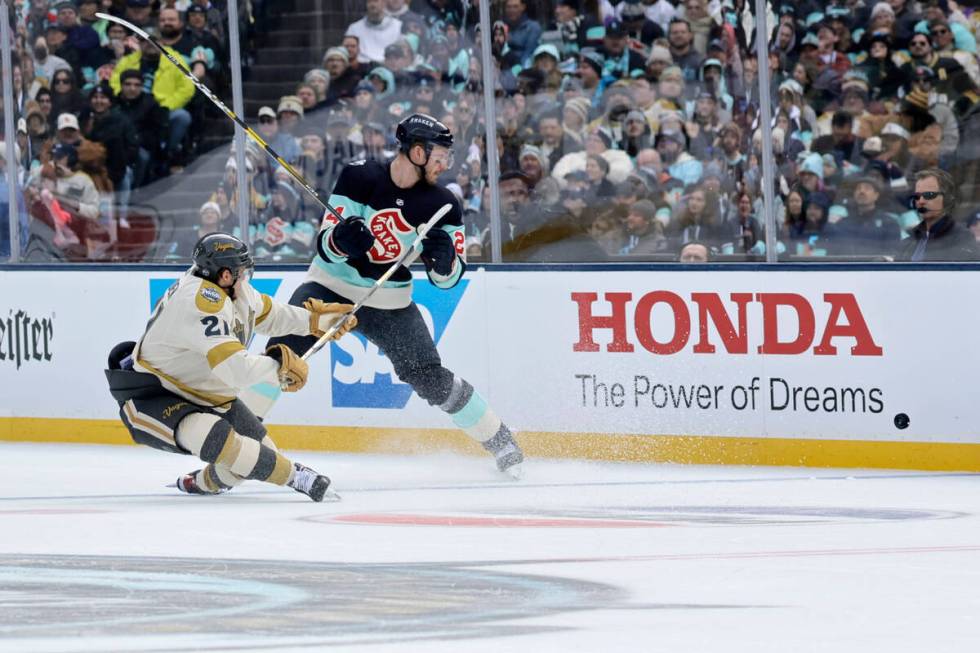 Vegas Golden Knights center Brett Howden (21) goes down after he was hit by Seattle Kraken defe ...